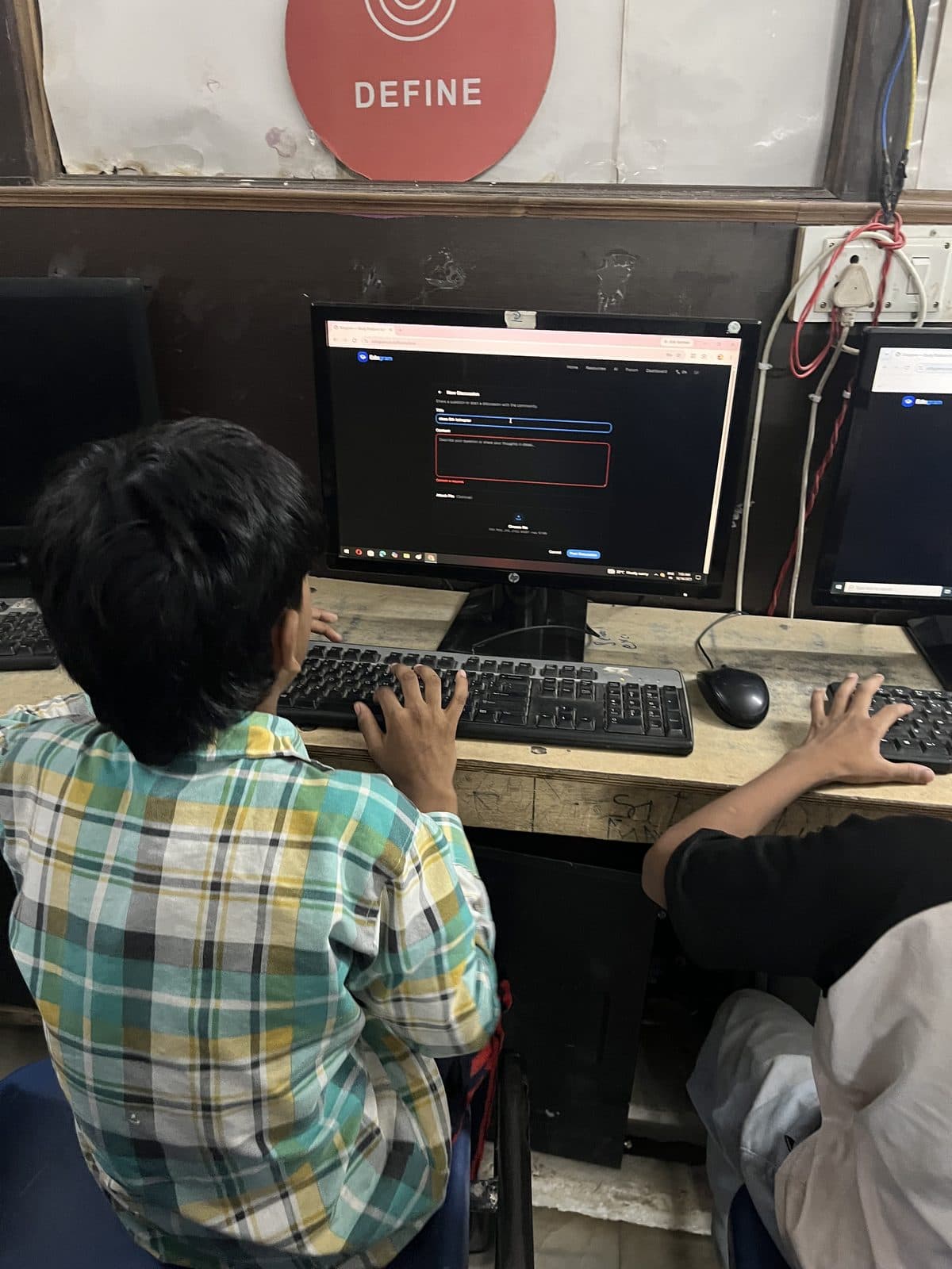 A student at Prayatna typing into the Edugram site on a desktop computer.